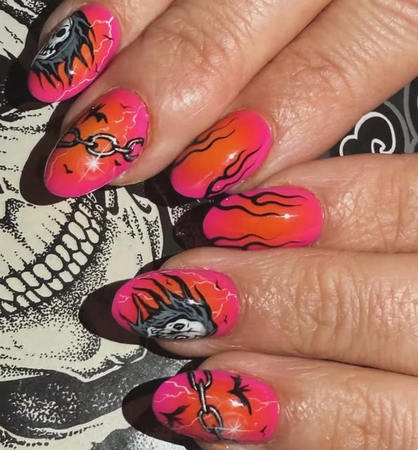 Orange and pink hand-painted nails with dark motifs